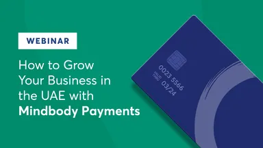 Blue credit card on a plain green color background