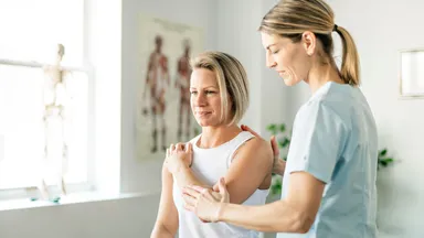 Woman gets adjusted by female chiropractor in her office