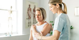 Woman gets adjusted by female chiropractor in her office