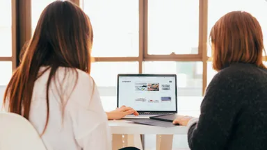 two women working on a website